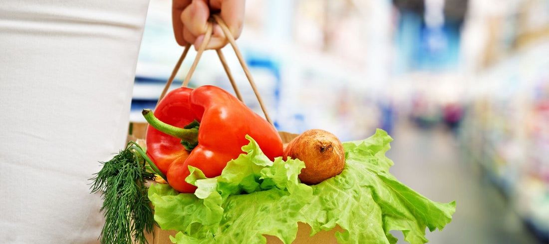 Woman holding grocery bag filled with veggies